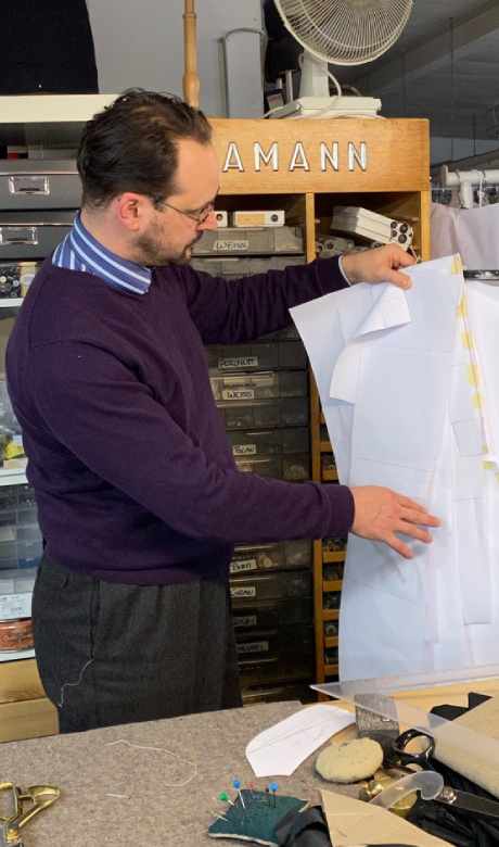 Uwe Müller begutachtet ein Schnittmuster in seinem Schneideratelier