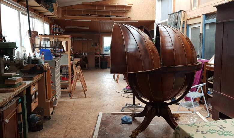 Dieser Sekretär in Form eines Globus wird gerade in der Werkstatt des Restaurators aufgearbeitet
